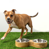 Dog running in grass past a Mango wood and metal dog feeder double diner - Green Paw Shop